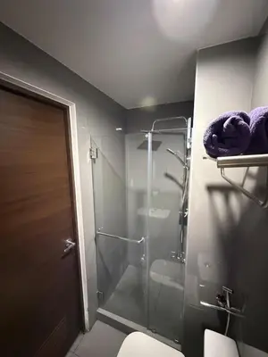 a bathroom with a glass shower and a toilet at Skyline Blue Air residences 1Br cityview by Tin & Aix in Manila
