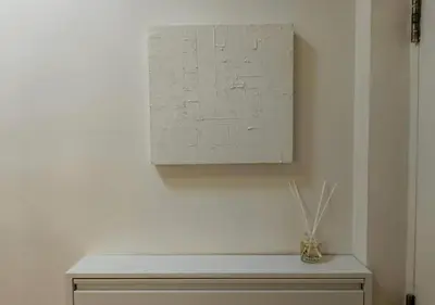 a white wall with a painting and a bench at Central Modern Cosy Condo in Makati - The Linear Suite in Manila