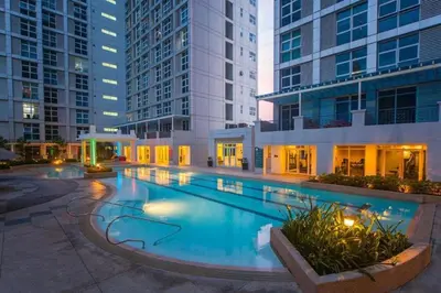 a large swimming pool in a building with tall buildings at Central Modern Cosy Condo in Makati - The Linear Suite in Manila