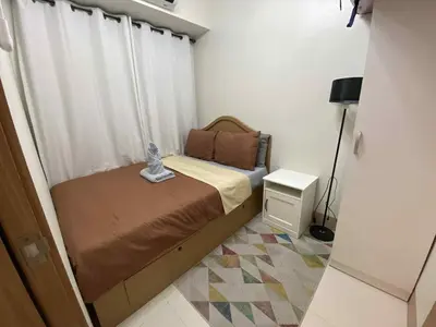a small bedroom with a bed and a window at Shore Condotel pasay manila in Manila
