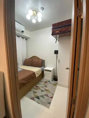 a small bedroom with a bed and a room with a floor at Shore Condotel pasay manila in Manila