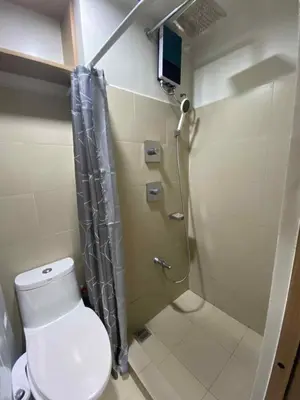 a bathroom with a shower and a toilet at Shore Condotel pasay manila in Manila