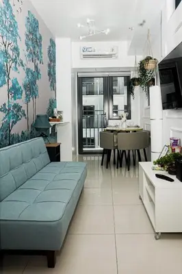 a living room with a blue couch and a table at Blue Horizon - Newly renovated condo near MOA in Manila