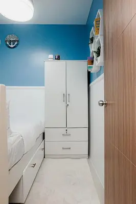 a bedroom with a bed and a white cabinet at Blue Horizon - Newly renovated condo near MOA in Manila
