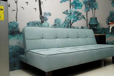 a blue couch in a room with a wall with trees at Blue Horizon - Newly renovated condo near MOA in Manila