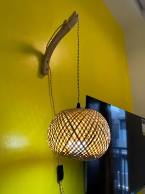 a wicker light hanging from a yellow wall at Lemon Room in S Residences near MOA, Airport, US Embassy by Prime Stay in Manila