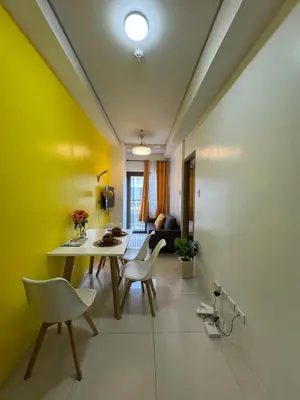 a dining room with yellow walls and a table and chairs at Lemon Room in S Residences near MOA, Airport, US Embassy by Prime Stay in Manila