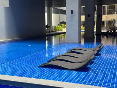a swimming pool with a chair in a building at Lemon Room in S Residences near MOA, Airport, US Embassy by Prime Stay in Manila