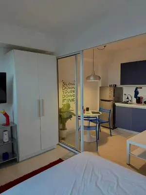 a living room with a table and a kitchen at Room at SM Bicutan GJ in Manila