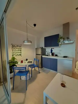 a kitchen with two blue chairs and a table and a counter at Room at SM Bicutan GJ in Manila