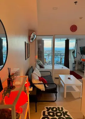 a living room with a couch and a room with a view at Room at SM Bicutan GJ in Manila
