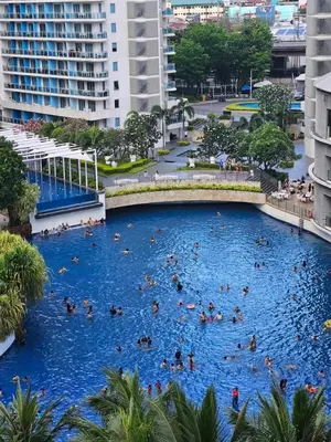 a group of people swimming in a large swimming pool at A2Z Staycation Miami Tower 15th Floor With Ps4 and Netflix in Manila