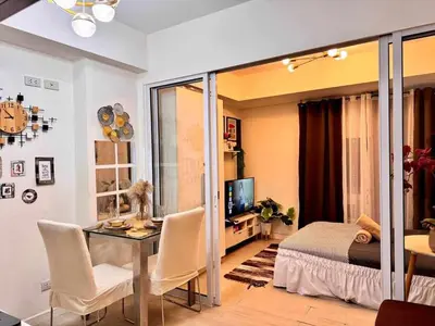 a living room with a table and a bedroom at A2Z Staycation Miami Tower 15th Floor With Ps4 and Netflix in Manila