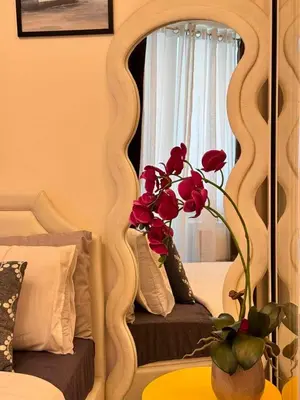 a mirror with a vase with a flower on a table at A2Z Staycation Miami Tower 15th Floor With Ps4 and Netflix in Manila