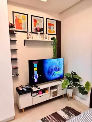 a living room with a flat screen tv on a entertainment center at A2Z Staycation Miami Tower 15th Floor With Ps4 and Netflix in Manila
