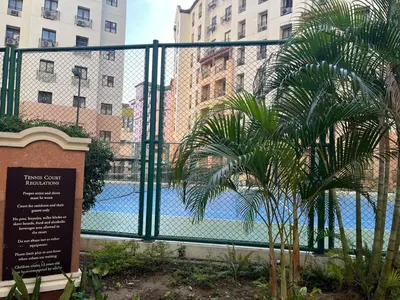 a fence with a palm tree in front of a pool at Spacious 2 Bed & 2 Bath Condo in Newport City in Manila
