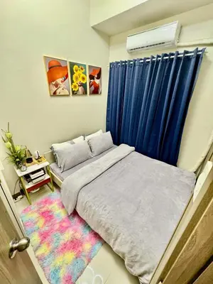 a bedroom with a bed and a blue curtain at Mitch Ace Staycation in Manila
