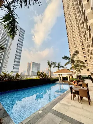 a swimming pool in the middle of two tall buildings at Mitch Ace Staycation in Manila