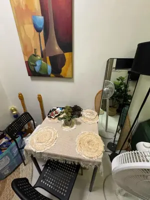 a table and chairs in a room with a painting at Mitch Ace Staycation in Manila