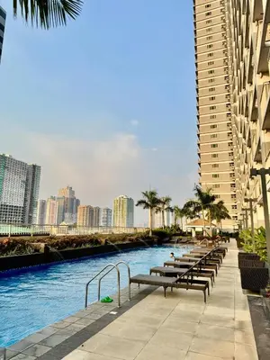 a row of benches next to a river with buildings at Mitch Ace Staycation in Manila