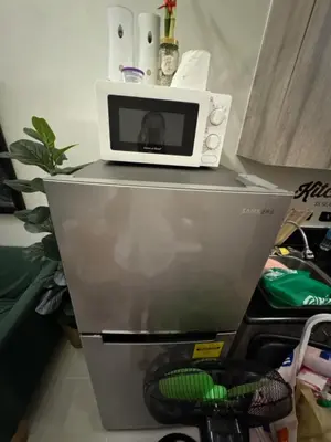 a microwave sitting on top of a refrigerator at Mitch Ace Staycation in Manila