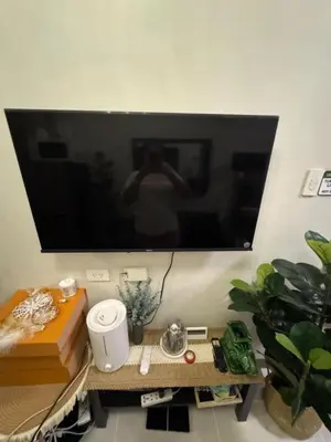 a person taking a picture of a television on a wall at Mitch Ace Staycation in Manila
