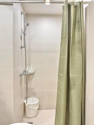 a bathroom with a shower with a toilet and a sink at 1BR with Pool View Near NAIA Long Stay Ready in Manila