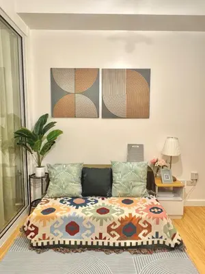 a bedroom with a bed and some paintings on the wall at 1BR with Pool View Near NAIA Long Stay Ready in Manila