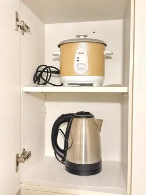 a pot and a tea kettle in a cupboard at 1BR with Pool View Near NAIA Long Stay Ready in Manila