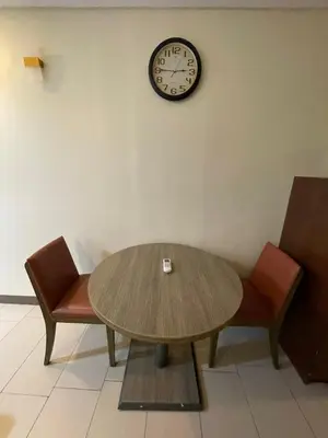 a table and two chairs and a clock on a wall at Antel Spa Residences 9D in Makati