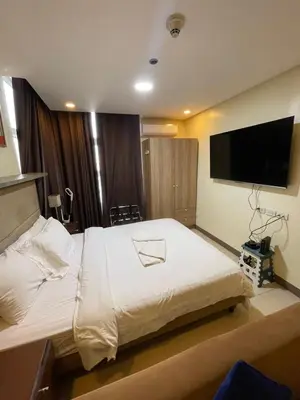 a bedroom with a large bed with a flat screen tv at Antel Spa Residences 9D in Makati