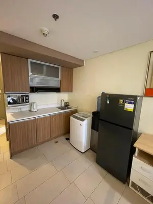 a kitchen with a black refrigerator and a sink at Antel Spa Residences 9D in Makati