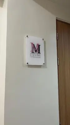a sign on a wall with the letter m on it at Modern 1-BR Retreat with Pool, High Speed Wifi, Netflix, steps from MOA, Bars, Entertainment, Transport in Manila