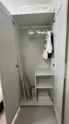 a small white closet with a white door and shelves at Modern 1-BR Retreat with Pool, High Speed Wifi, Netflix, steps from MOA, Bars, Entertainment, Transport in Manila