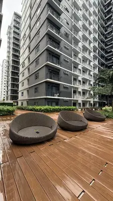 a row of circular objects on a wooden deck in front of a building at Modern 1-BR Retreat with Pool, High Speed Wifi, Netflix, steps from MOA, Bars, Entertainment, Transport in Manila