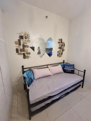 a bed in a room with pictures on the wall at My little Apartment in Manila