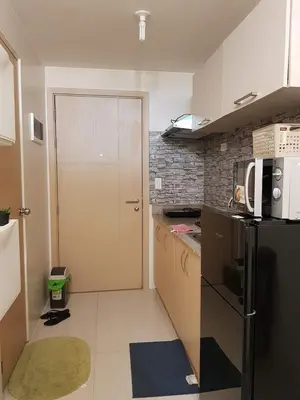 a small kitchen with a refrigerator and a door at My little Apartment in Manila