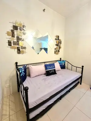 a bed in a room with some pillows on it at My little Apartment in Manila