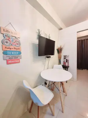 a living room with a white table and a tv at My little Apartment in Manila
