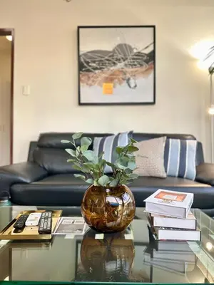 a living room with a vase on a glass table at 1BR Corner Unit with Balcony in Manila