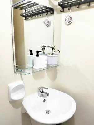 a bathroom with a white sink and a mirror at Studio Near Mall & Airport! in Manila