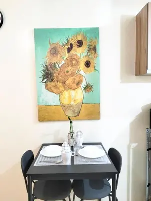 a dining room table with a painting of sunflowers at Studio Near Mall & Airport! in Manila