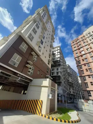 a building in front of some tall buildings at Studio Near Mall & Airport! in Manila