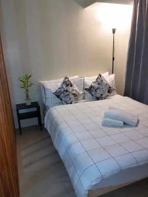 a bedroom with a white bed and a lamp at Studio Near Mall & Airport! in Manila