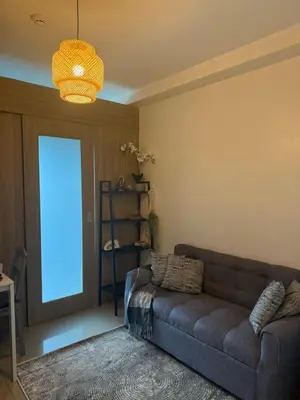 a living room with a couch and a large window at City View Facing Moa in Manila