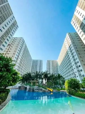 a large swimming pool in the middle of two tall buildings at Cozy Couple Room in Manila