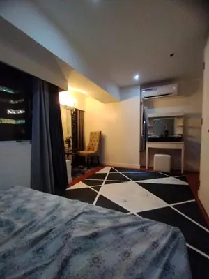 a bedroom with a bed and a checkerboard floor at Urban Nest in Manila