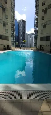 a large swimming pool in a building with tall buildings at Urban Nest in Manila