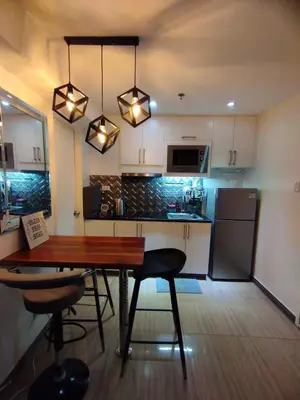 a kitchen with a wooden table and chairs and a dining room at Urban Nest in Manila