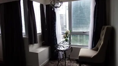 a living room with a chair and a window at Urban Nest in Manila